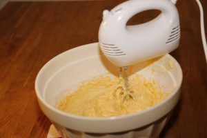5. バターと砂糖に、かき混ぜた卵、薄力粉、ベーキングパウダーを加えて、ゴムべらでまんべんなく混ぜ合わせる。電子ミキサーを使用すると簡単にできる。