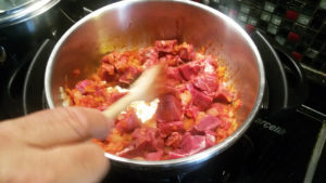 4.3に肉とサルチャ（またはトマトのペースト）を入れて、肉に少し焼き色がつく程度まで炒める。