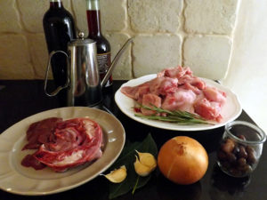 （右手前から時計回りに）黒オリーブ、玉ねぎ、にんにく、ローリエ、ウサギの頭部とレバー、赤ワイン、エクストラ・バージン・オリーブオイル、ワインビネガー、ウサギ肉、ローズマリー
