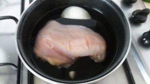 鶏むね肉をニンニク1かけと、多少の玉ねぎと一緒に中火で15分を目安にゆでます。